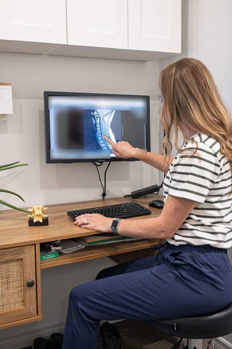 A chiropractor reviewing spine imaging at her desk