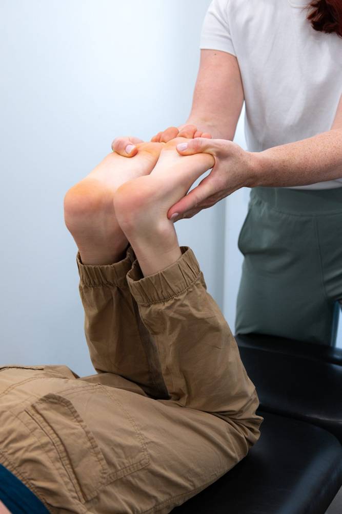 A practitioner mobilizing a patient’s feet