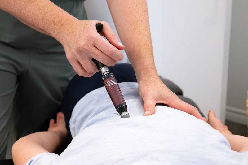 A gentle instrument-assisted adjustment on a child’s back